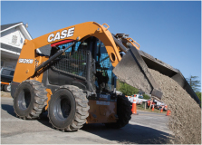 CASE wheel skid steer loader dumping dirt onto a paved roadway under a blue sky background, ideal for earth moving projects.