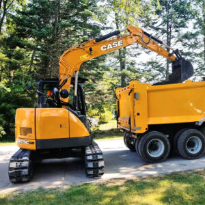 CASE CX75C DR dropping items into the back of a dumpster truck surrounded by trees