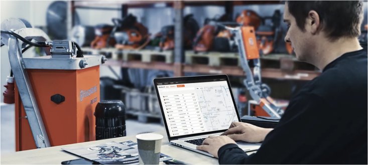 man checking Husqvarna Fleet Services on a laptop