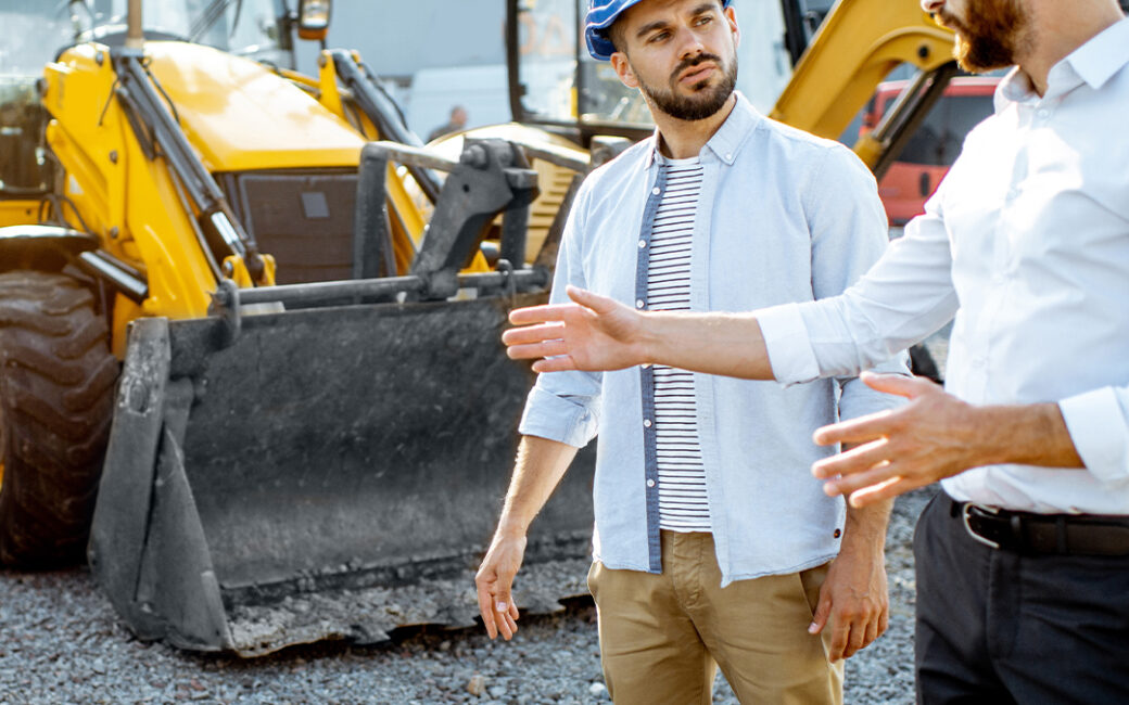 Equipment salesman shows customer product.