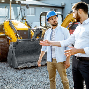 Equipment salesman shows customer product.