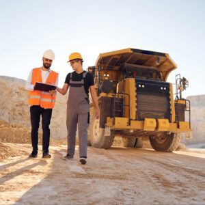 Two men talking in front of construction equipment