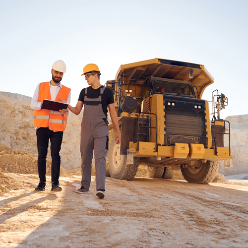 Two men talking in front of construction equipment
