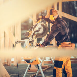Man on construction site using power saw