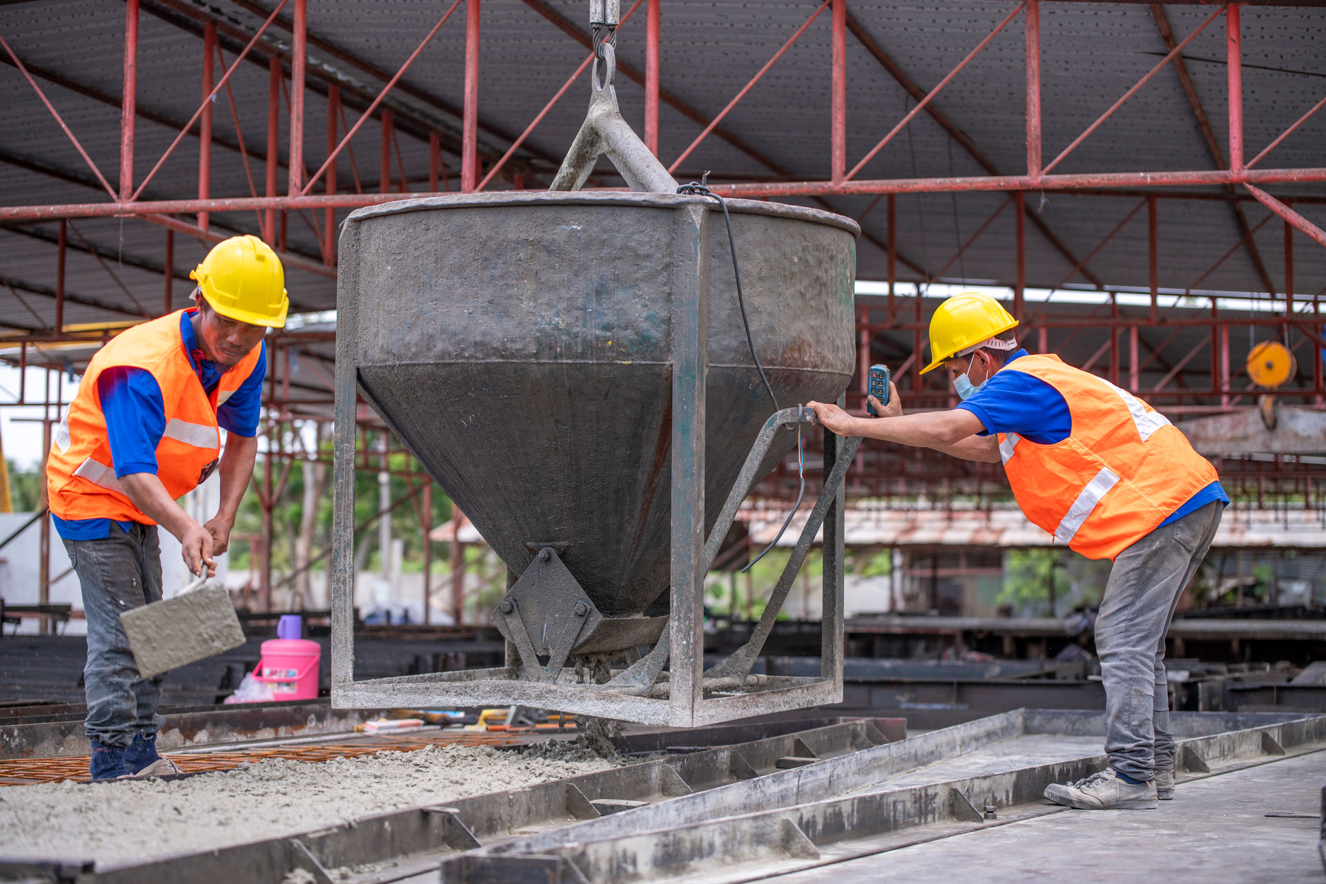 Worker are working at a construction site worker is handling a tool, possibly a trowel, while the ot Worker are working at a construction site worker is handling a tool, possibly a trowel, while the ot
